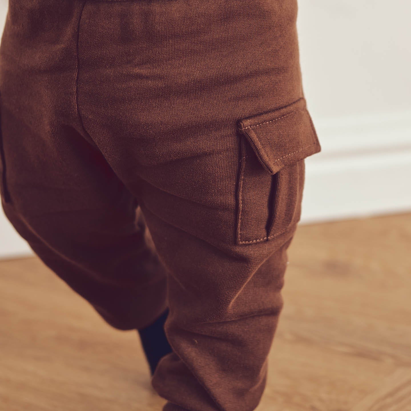 Baby wearing brown cargo leggings with pocket detail for comfort and style.