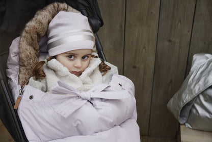 Baby in stroller cozy in lavender Fußsack, ideal for winter warmth and style, beloved by design-oriented parents.