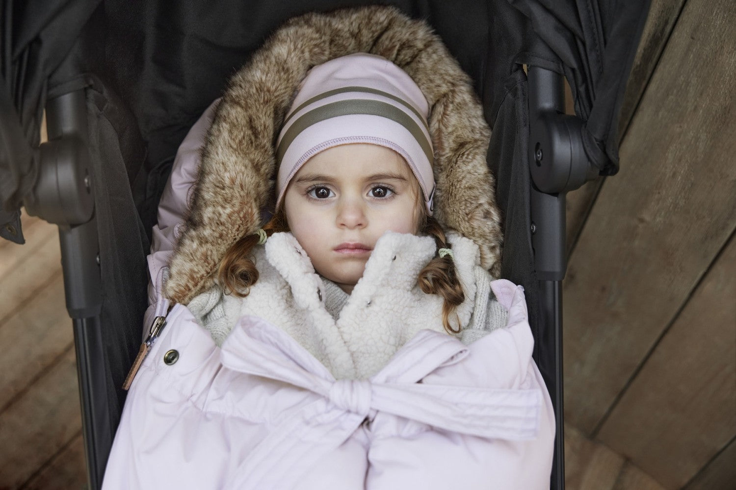 Cozy baby in stroller with Lavender Love Fußsack, featuring thick padding and temperature regulation for winter warmth.