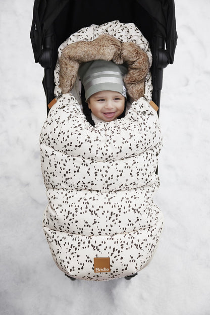 Baby in stroller wrapped in Fußsack with Dalmatian Dots, perfect for cold weather outings.