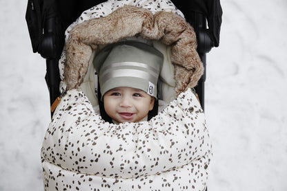 Baby smiling in stroller with Dalmatian Dots Fußsack, ideal for winter warmth and style.