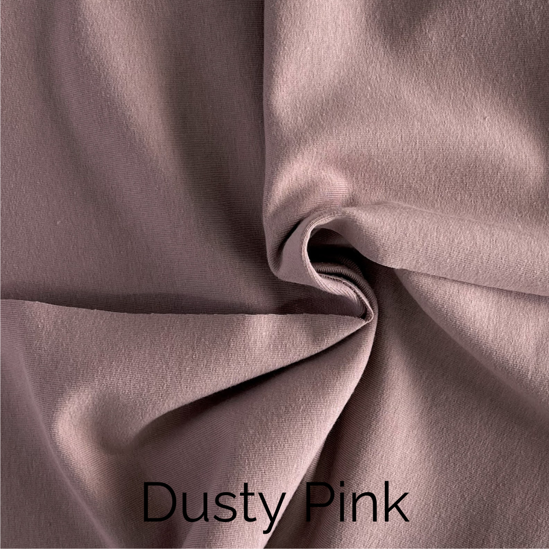 Soft dusty pink fabric showcasing its smooth texture and elegant drape for stylish decor.